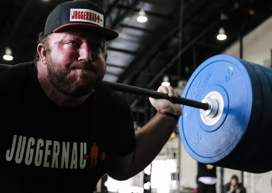 Lifter squatting a barbell during a gym training session